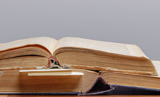 istock two old open books with bookmarks lie on a wooden table, close-up 1299743955