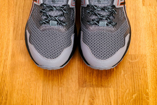 New gray running shoes on parquet floor background. New gray running shoes on parquet floor background. running shoes on floor stock pictures, royalty-free photos & images