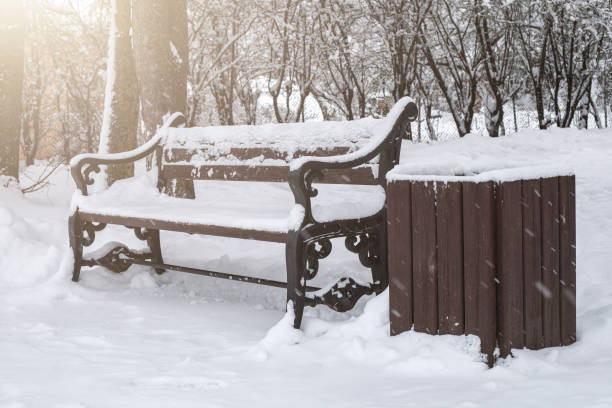 istock Snowy bench in the park. Snowfall and weather 1299744669
