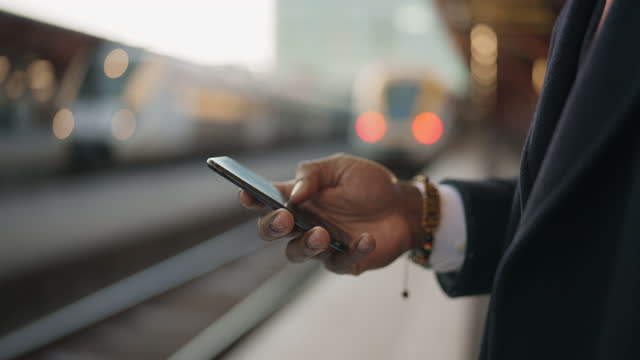 Businessman using his smartphone at the train station