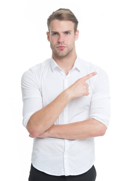 istock Manager or assistant help find direction. Pointing direction. Man shop assistant pointing index finger isolated on white. Look at this advertisement. This way concept. Guy handsome shows direction 1299745761