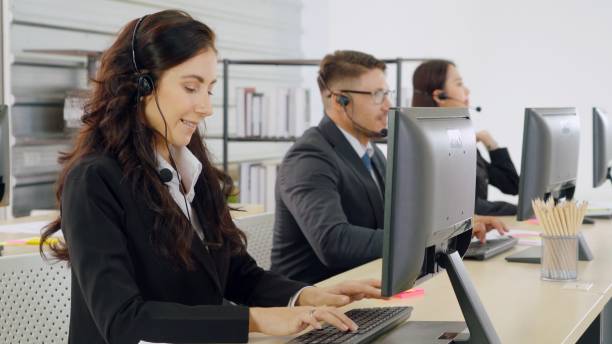 istock Business people wearing headset working in office 1299745862