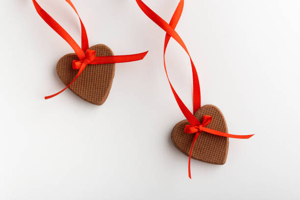 istock Two gingerbread hearts on Valentines Day with red ribbon on white background. Close up 1299746192