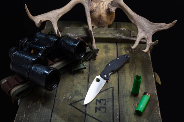 istock Pocket knife and touring binoculars. Deer antlers, knife and binoculars. View from above. 1299746540