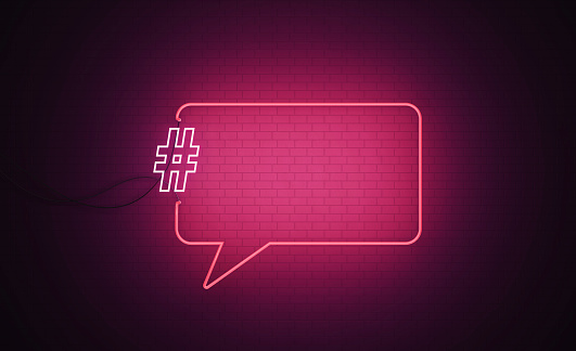 Speech bubble shaped pink neon light and white exclamation point  sitting on black wall. Horizontal composition with copy space. Great use for danger, risk and warning concepts.