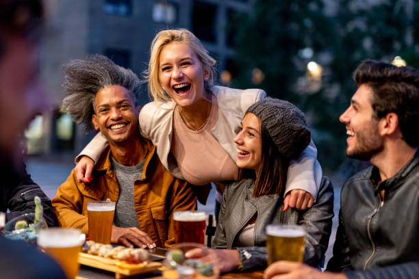 양조장에서 웃고 마시는 친구 그룹, 맥주와 함께 토스트하고 covid19 발발 후 젊은이들의 융합 음식, 밤 문화 및 사교 모임을 먹는 밀레니엄 세대부부를 만났습니다. - smart casual outdoors friendship happiness 뉴스 사진 이미지