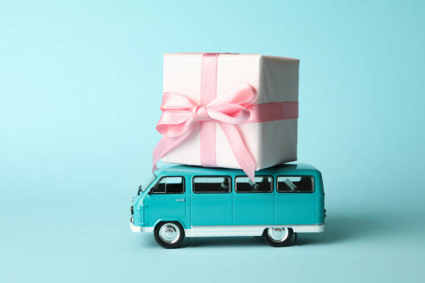 istock Toy van with gift box on blue background 1299748118