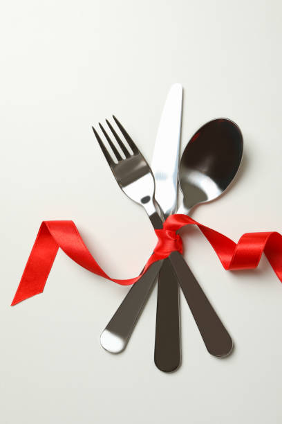 istock Cutlery with red ribbon on white background 1299748892