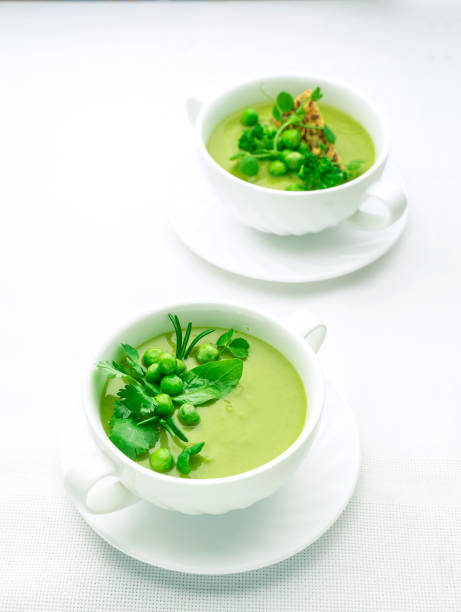 istock Green pea puree soup on white plate with place for text 1299749067