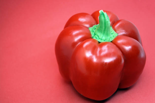 istock The fruit of a red sweet pepper on a red background. 1299749376