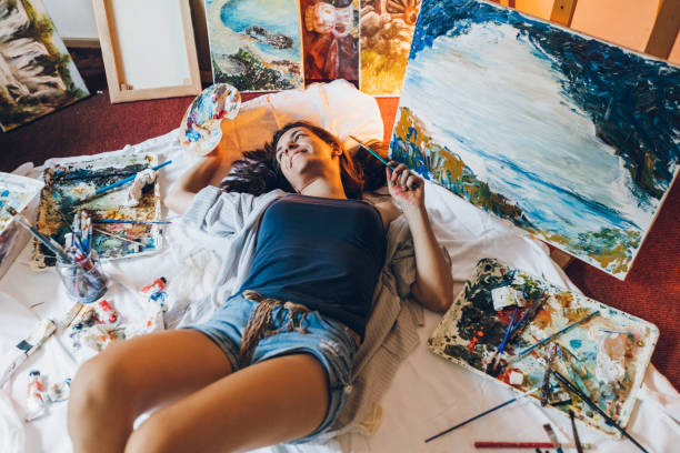 istock Woman painter surrounded with her art 1299749493