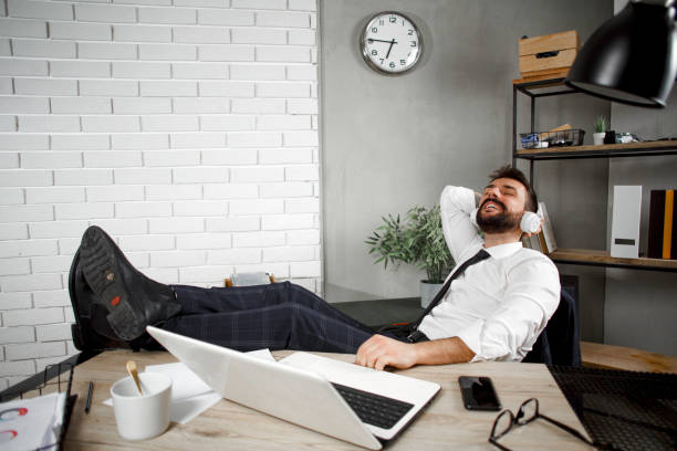 istock Young businessman with headphones singing at work. 1299750550
