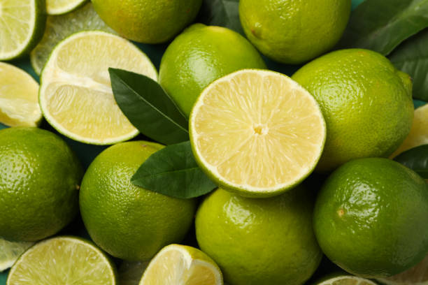 istock Fresh ripe lime with leaves on whole background 1299751111