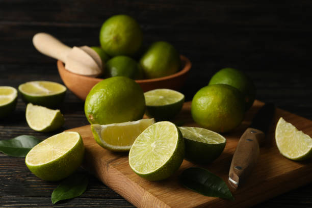 istock Bowl and board with lime on wooden background 1299751812