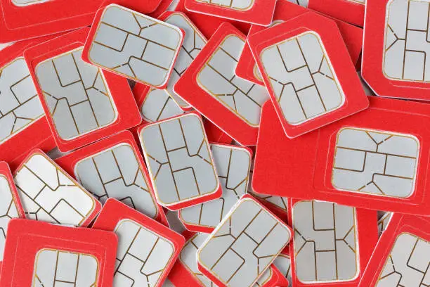 Red SIM cards of various formats heap, close-up, top view