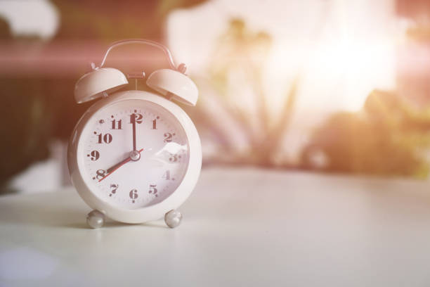 istock Selective focus of alarm clock show 8 o'clock or 8 a.m. on table with nature bokeh background. Time in life concept. 1299753541