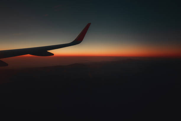 Travel view window plane at sunset with mountains and clouds at background. Space for text.