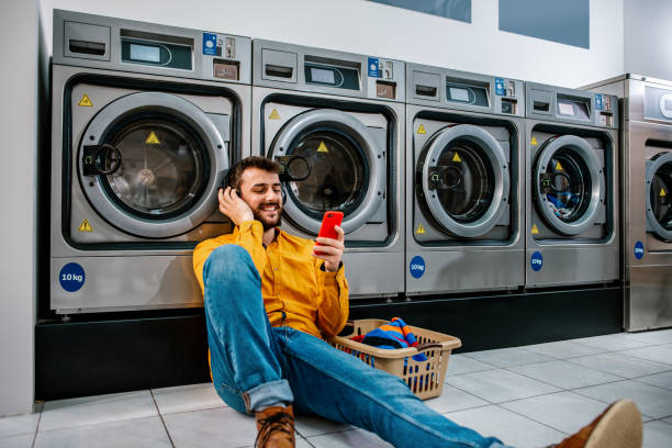 joven lavando su ropa - all laundry detergent audio fotografías e imágenes de stock