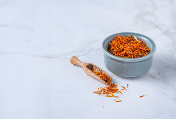oriental spice saffron in a blue ceramic bowl on a marble table oriental spice saffron in a blue ceramic bowl on a marble table. Copy space substitute for saffron stock pictures, royalty-free photos & images