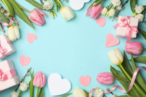 istock 8 march concept with different flowers and gift boxes on blue background, space for text 1299758391