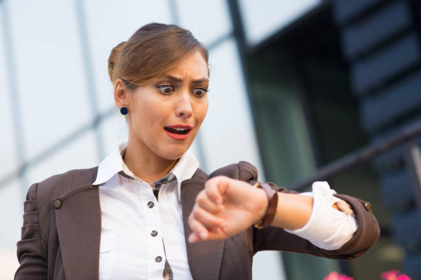 istock Businesswoman in front of office building checking time 1299758410