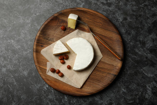 istock Board with camembert and hazelnut on black smokey background 1299759776