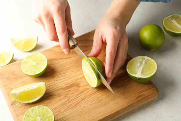 istock Woman cuts lime on cutting board, close up 1299760967