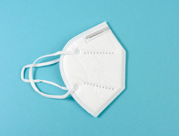 istock white disposable medical mask on a blue background, personal protective equipment for the respiratory tract from viral infections 1299761004