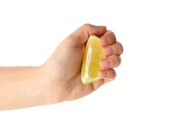istock Female hand hold lime slice, isolated on white background 1299761101