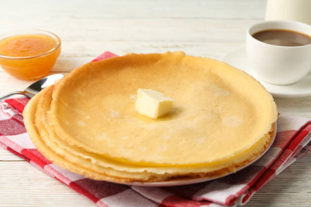 istock Concept of tasty breakfast with thin pancakes on white wooden table 1299763231