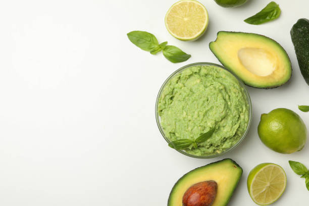 istock Bowl of guacamole, avocado, lime and basil on white background, space for text 1299763548
