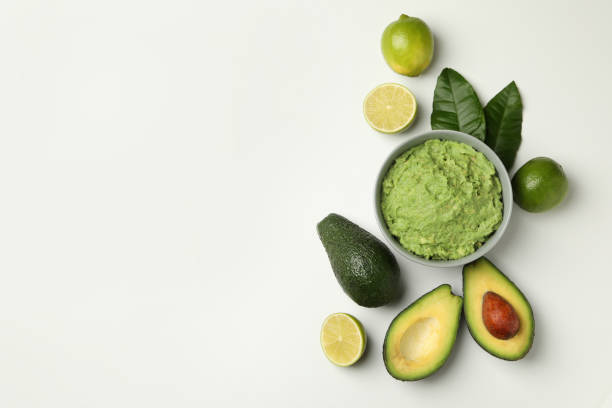 istock Bowl of guacamole, avocado and lime on white background, space for text 1299764917
