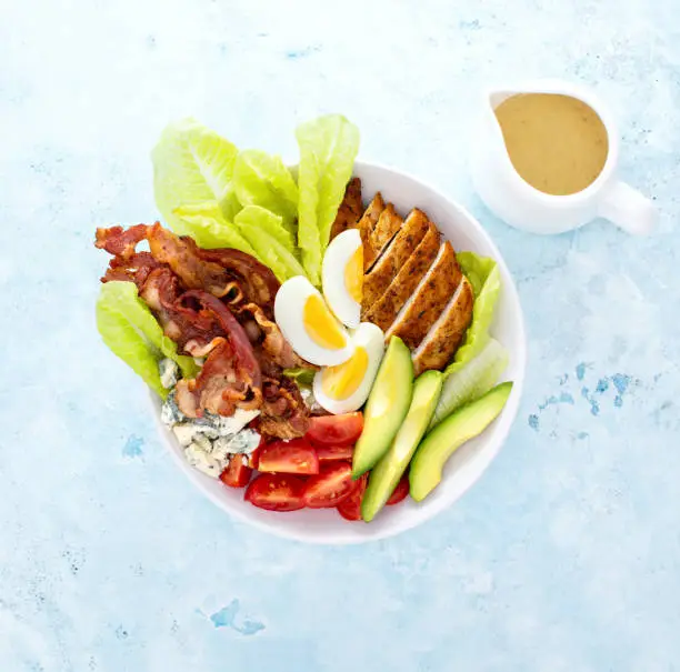 Photo of Cobb salad bowl served with spicy dressing