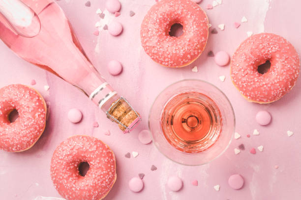 розовое вино или коктейль с розовыми пончиками и розовыми шоколадными бобами - pink champagne стоковые фото и изображения