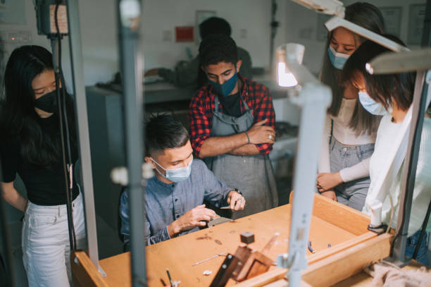 asian malese gioiello design docente dimostrando mostrando la creazione di gioielli ai suoi studenti al workshop workbench - jewelry craftsperson craft jeweller foto e immagini stock