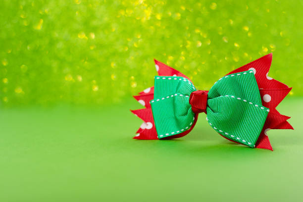A red ribbon is tied in a bow, with a white trim. The ribbon is a beautiful and elegant accessory, perfect for adding a touch of glamour to any outfit. The bow is tied in a neat and tidy manner