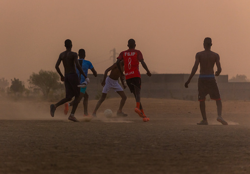 Kids playing football at sunset in Maroua