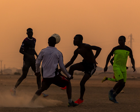 Kids playing football at sunset in Maroua