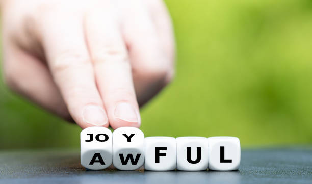 istock Hand turns dice and changes the word awful to joyful. 1299768302