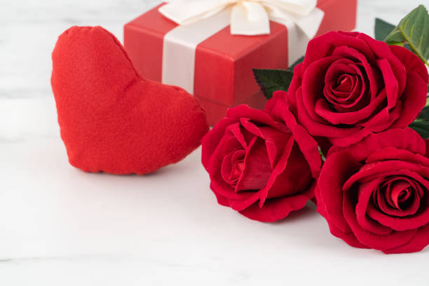 istock Valentine's Day design concept background with rose flower and gift box. 1299768384