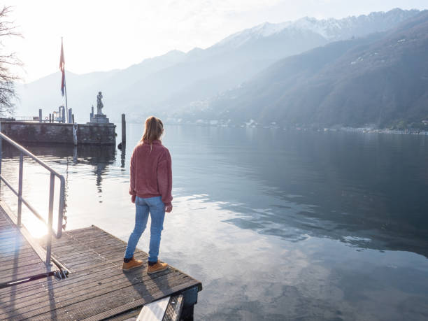 istock Young woman relaxing on pier at sunset 1299769087
