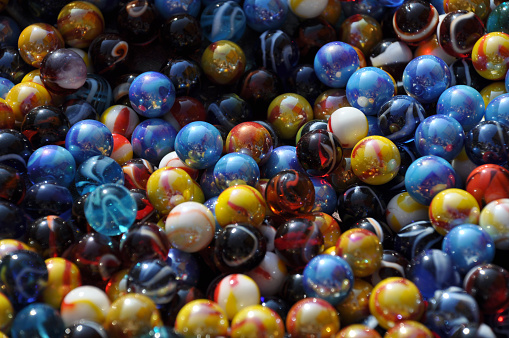 A collection of well used colorful glass marbles from  children's play in the past.