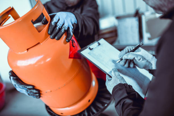 trabajadores de almacenamiento de gas licuado que escriben el número de serie del cilindro - liquid propane gas fotografías e imágenes de stock