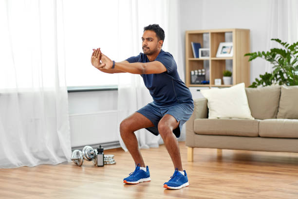 istock indian man exercising and doing squats at home 1299769703