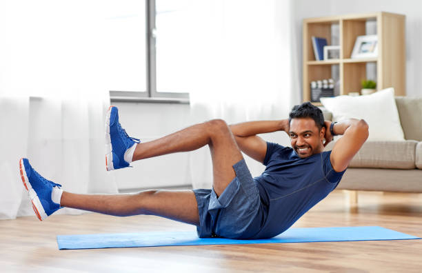 indian man making abdominal exercises at home sport, fitness and healthy lifestyle concept - indian man making abdominal exercises at home bodyweight training photos stock pictures, royalty-free photos & images