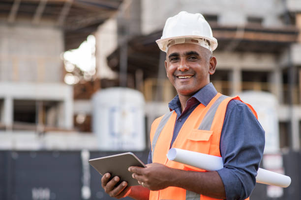 Engineer at construction site, using digital tablet Engineer at construction site, using digital tablet construction worker stock pictures, royalty-free photos & images