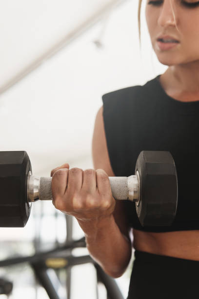 istock Female hand with a dumbbell during biceps curl exercise 1299772604