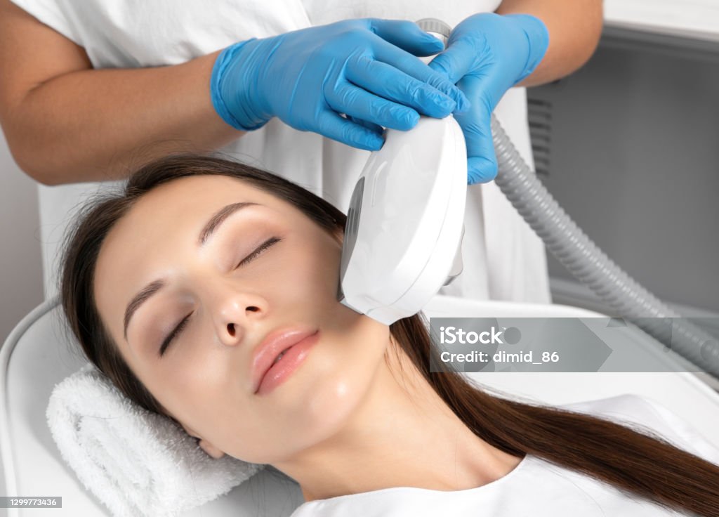 Elos epilation hair removal procedure on the face of a woman. Beautician doing laser rejuvenation in a beauty salon. Facial skin care. Hardware  ipl cosmetology Facial Mask - Beauty Product Stock Photo