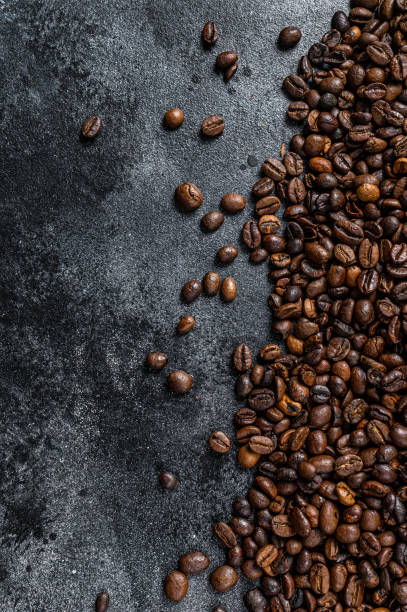 granos de café tostados en mesa rústica. fondo negro. vista superior. copiar espacio - coffee black coffee cup coffee bean fotografías e imágenes de stock