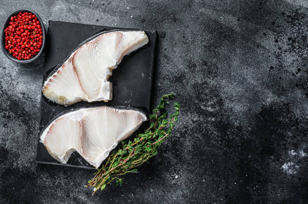 istock Raw Shark fish steaks on a board. Black background. Top view. Copy space 1299774858